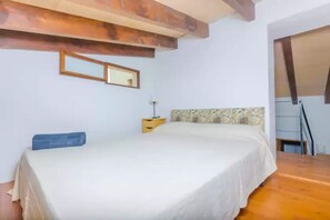 Une chambre à coucher comprenant un lit, une table de chevet, un miroir et une tête de lit à motifs.