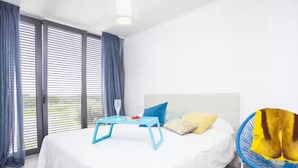 A bedroom with a bed, a table with a glass, and a fan. - S'aigua 5 - Villa With Private Pool In S'illot (S'illot, Illes Balears)