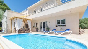 A modern house with a swimming pool, outdoor seating, and a covered patio area. - Xalet S'escaleta - Villa With Private Pool (Cala Santanyí, Illes Balears)