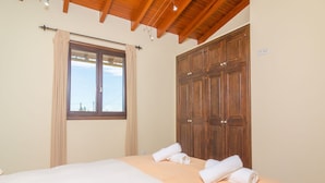 A bedroom with a large bed, wooden wardrobe, and a window with curtains. - S'alqueria - Villa With Private Pool In Campanet (Campanet, Illes Balears)