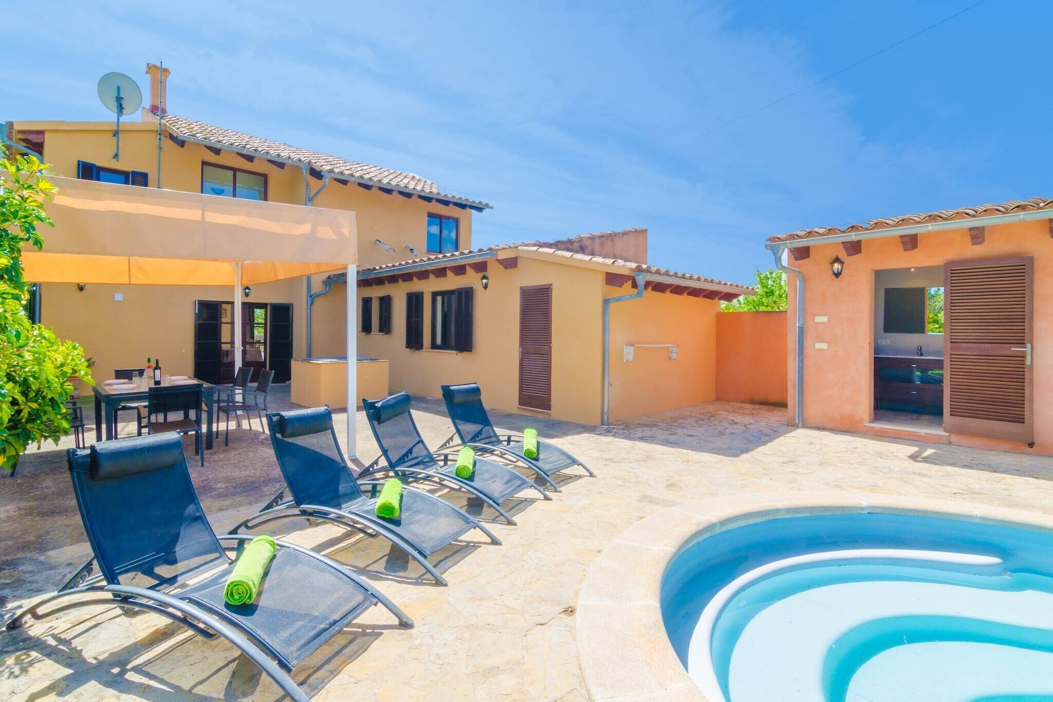 A poolside area with lounge chairs, a dining table, and a small pool.
