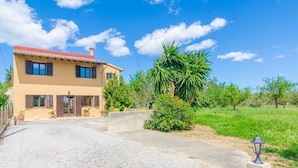 A two-story house with a red-tiled roof, a gravel driveway, and a well-maintained garden with a palm tree. - S'alqueria - Villa With Private Pool In Campanet (Campanet, Illes Balears)