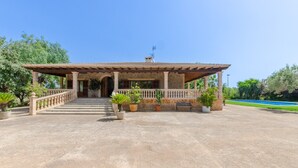 A stone building with a covered entrance, steps leading up to it, and potted plants around. - Ca'n Berguins - Villa With Private Pool In Búger (Buger, Illes Balears)
