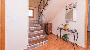 Una scala con gradini decorati conduce a una zona d'appoggio con uno specchio e un tavolino consolle.