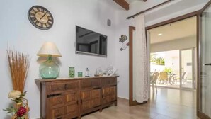 A wooden cabinet with a green lamp, a wall clock, and decorative items.