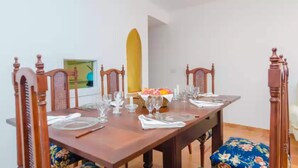 A dining table set for six with wooden chairs, a fruit basket, and a yellow object on the wall. - Can Salas - Apartment In Porreres. Free Wifi (Porreres, Illes Balears)