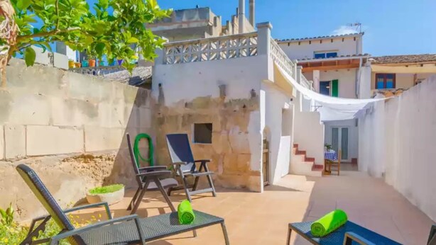 A courtyard with outdoor seating, a staircase, and a building in the background. - Can Salas - Apartment In Porreres. Free Wifi (Porreres, Illes Balears)