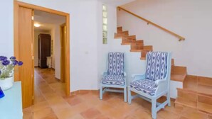 A staircase with a wooden handrail and a patterned chair in the foreground. - Can Salas - Apartment In Porreres. Free Wifi (Porreres, Illes Balears)