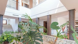 A spacious indoor area with a high ceiling, stone columns, and a variety of potted plants. - Turixant Dalt - Villa With Private Pool. Free Wifi (Mancor De La Vall, Illes Balears)