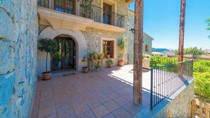 A stone building with a balcony, potted plants, and a view of the landscape. - Turixant Dalt - Villa With Private Pool. Free Wifi (Mancor De La Vall, Illes Balears)