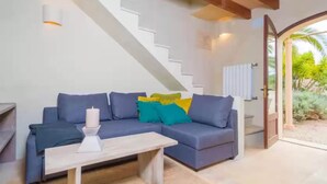 A modern living room with a sofa, a coffee table, and a staircase. - Can Pina - Eco Redonda 1 - - Apartment In Costitx (Costitx, Illes Balears)