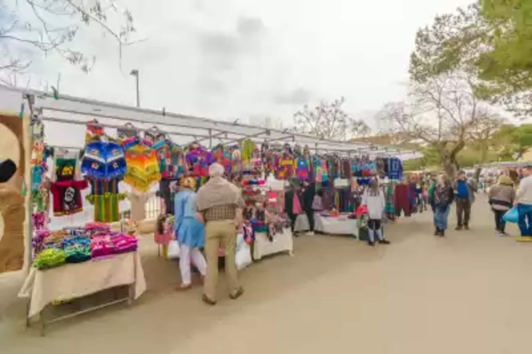Ein Markt mit verschiedenen Ständen, die bunte Waren anbieten.