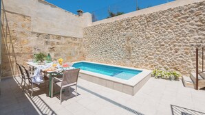 A swimming pool with a stone wall, a table with chairs, and a small garden area. - Can Diana - Villa With Private Pool In Campanet (Campanet, Illes Balears)