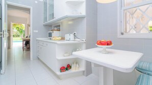 A modern kitchen with white cabinetry, a built-in oven, and a fruit bowl on the counter. - Can Ferro - Villa With Private Pool In Cala Blava (Cala Blava (llucmajor), Illes Balears)