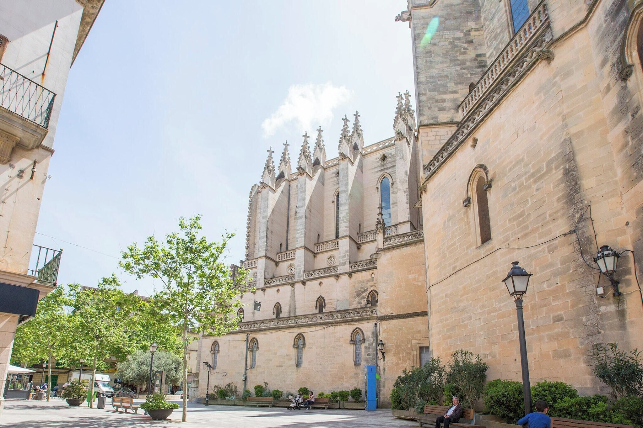 A historic building with a large courtyard, benches, and street lamps.