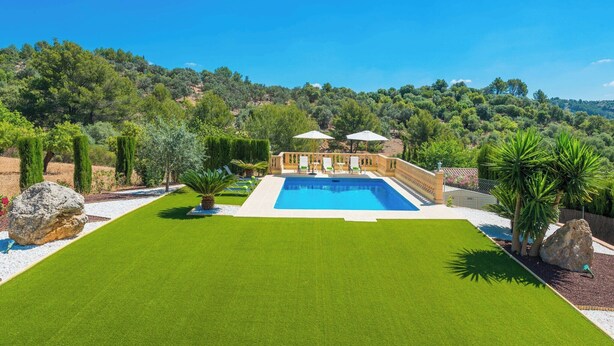 Un espace piscine offrant une vue dégagée sur le paysage environnant, notamment sur les arbres et les collines.