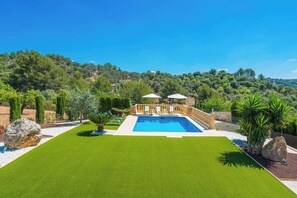Un área de piscina con vistas despejadas del paisaje circundante, incluyendo árboles y colinas.