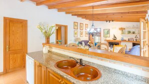 A kitchen with wooden beams, granite countertops, and a double sink. - Casa Mas - Villa With Private Pool In Felanitx (Felanitx, Illes Balears)