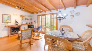 A cozy dining area with wicker chairs, a round table, and a fireplace. - Casa Mas - Villa With Private Pool In Felanitx (Felanitx, Illes Balears)