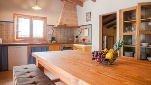 A kitchen with a wooden table, a fruit bowl, and a built-in oven. - Son Morro - Villa With Private Pool. Free Wifi (Santa Margalida, Illes Balears)