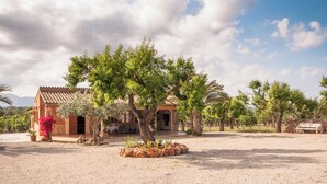 A rustic villa with a tiled roof, surrounded by trees and a gravel courtyard. - Son Morro - Villa With Private Pool. Free Wifi (Santa Margalida, Illes Balears)