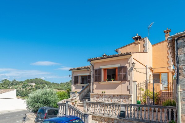 Traditional two-story building with a balcony and garden area.