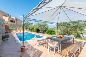 Relax by the serene pool surrounded by lush greenery and a stone wall.