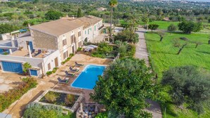 A villa with a swimming pool, outdoor seating, and a view of the surrounding countryside. - Can Salvador - Villa With Private Pool In Moscari (Moscari (selva), Illes Balears)