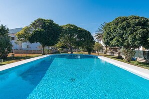A rectangular swimming pool with clear blue water, surrounded by well-maintained greenery and white buildings. - Ropit - Apartment In Port D'alcúdia. Free Wifi (Port D'alcúdia, Illes Balears)