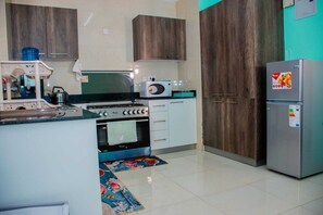Family Apartment, Balcony, City View | Private kitchen | Fridge, microwave, cookware/dishes/utensils, dining tables