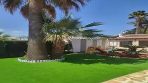 A residential area with a well-maintained lawn, a palm tree, and a play structure. - Gladiolo - Villa With Private Pool (El Tosalet - Xàbia, Alicante)