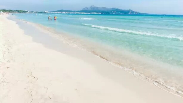 A beach with clear turquoise water, a sandy shore, and a distant mountain range. - Llepol - Apartment In Port D'alcúdia. Free Wifi (Port D'alcÚdia, Illes Balears)