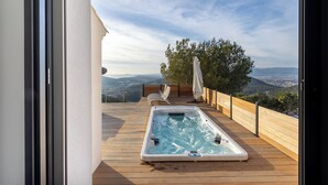 A hot tub on a wooden deck with a view of the city and hills. - Villa Vue Mer 180 - Face aux îles d’Or (Carqueiranne)