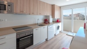 A modern kitchen with a microwave, oven, sink, and washing machine. - Torres Del Mar - Apartment In Grau I Platja (Playa De Gandia, Valencia)