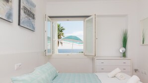 A bedroom with a bed, a dresser, a window with an open view, and a mirror. - Ses Roques De Cala Bona - Apartment In Cala Millor (Cala Millor, Illes Balears)