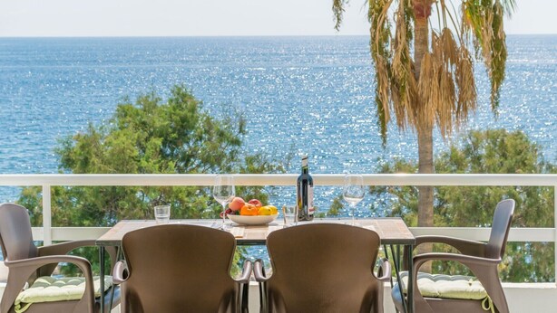 A balcony with a table set for two, overlooking a sea view. - Ses Roques De Cala Bona - Apartment In Cala Millor (Cala Millor, Illes Balears)