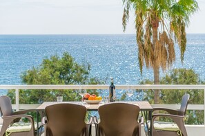 Een balkon met een tafel voor twee, met uitzicht op zee.