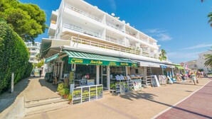 A coastal building with a restaurant named 'Costa' on the ground floor, featuring outdoor seating and a signboard with various food options. - Ses Roques De Cala Bona - Apartment In Cala Millor (Cala Millor, Illes Balears)
