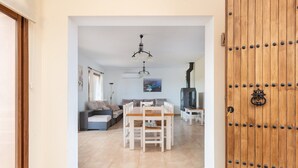 Ein Wohnzimmer mit einem Holzesstisch, einer Couch und einem Fernseher.