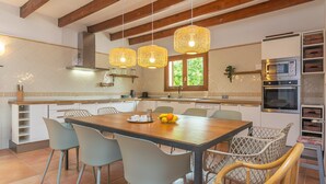 Une cuisine moderne avec une table à manger en bois, des chaises et un four encastré.