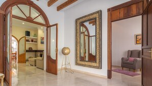 A spacious living area with a polished tiled floor, a large ornate mirror, and a cozy seating area with a grey sofa. - Unio 36 - Villa With Private Pool In Ariany (Ariany, Illes Balears)