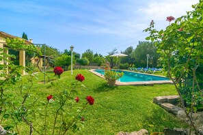 A swimming pool surrounded by a well-maintained lawn and flowering plants. - Marina (pollenÇa) - Villa With Private Pool (, Illes Balears)