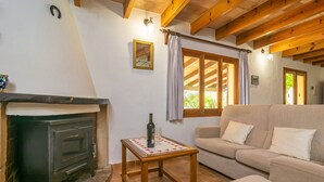 A cozy living room with a fireplace, a sofa, and a table with a bottle and glass.