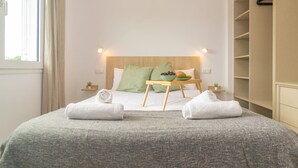 A neatly arranged hotel room with a bed, a bedside table with a bowl of fruit, and a wardrobe. - Ona 2 - Apartment In Cala D'or. Free Wifi (, Illes Balears)