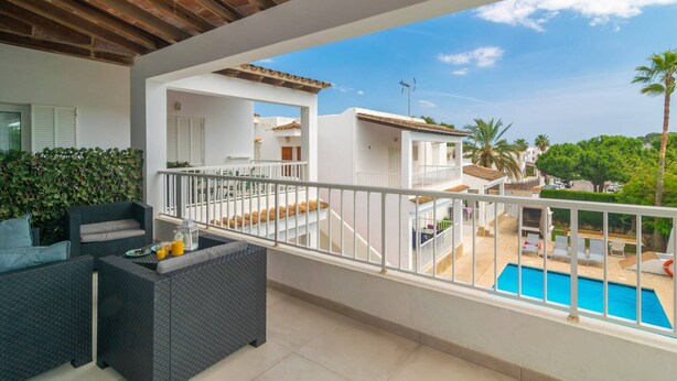 A balcony with outdoor furniture, a pool, and a view of neighboring buildings. - Ona 2 - Apartment In Cala D'or. Free Wifi (, Illes Balears)