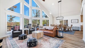 A spacious living room with high ceilings, large windows, and a cozy seating area.
