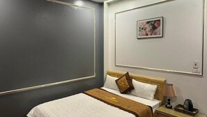 A hotel room with a bed, bedside table, lamp, and a framed picture on the wall. - Huong Que Hotel HN - by BAY LUXURY (Hanoi)