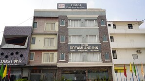 Un hotel de varios pisos con un cartel que indica que tiene habitaciones, un salón de banquetes y un restaurante.