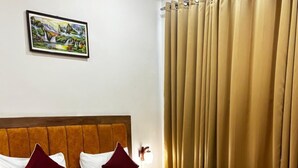 Una cama bien hecha con cabecera de madera, ropa de cama blanca y una manta roja.