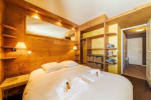 Una stanza in legno con un letto, scaffali e una porta.